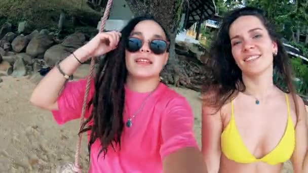 Frontansicht von zwei Damen in Sommerkleidung, die auf den Schaukeln unterwegs sind — Stockvideo