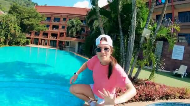 Mujer joven está bailando feliz cerca de la piscina y el hotel — Vídeo de stock