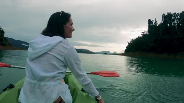 坐在皮划艇上，微笑的女士在飞溅 — 图库视频影像