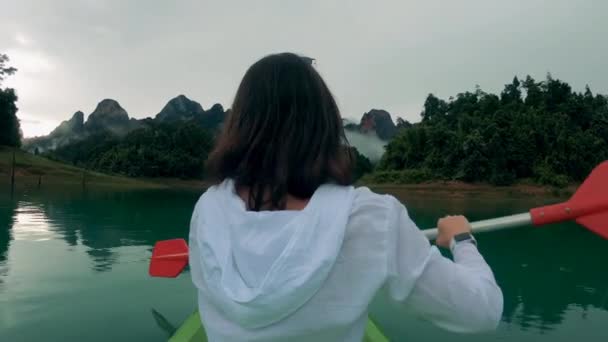 Movimiento lento de una dama que pasea en canoa cerca de las montañas — Vídeos de Stock