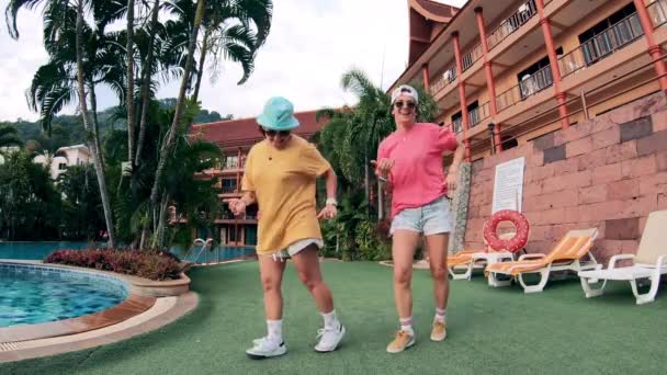 Danse ludique de deux jeunes femmes à côté de l'hôtel — Video