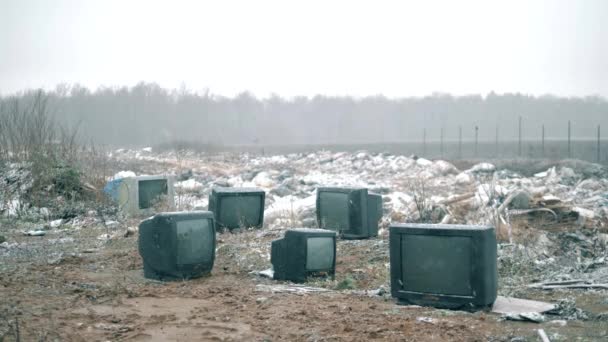 Een stortplaats met oude tv 's in de winter. — Stockvideo