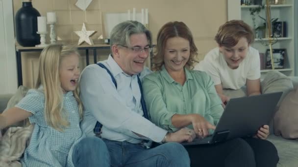 Grootouders en kleinkinderen gebruiken een laptop en lachen. — Stockvideo