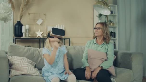 Uma menina está brincando com óculos VR enquanto está com sua avó — Vídeo de Stock