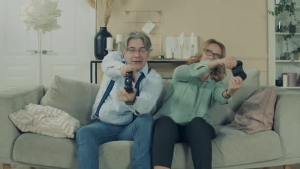 Homem e mulher idosos estão jogando um videogame — Vídeo de Stock