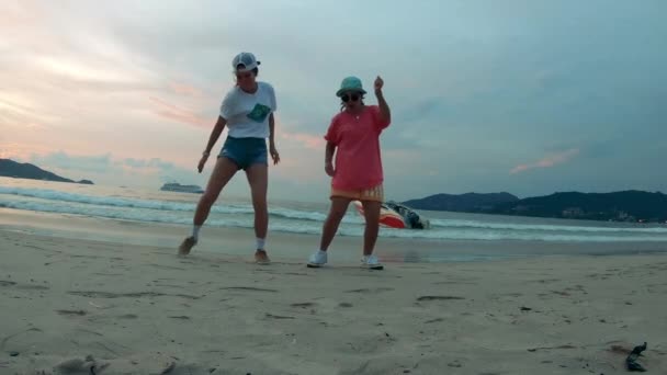 Twee dames dansen synchroon aan de kust. — Stockvideo