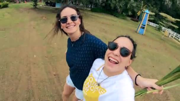 Mulheres sorridentes estão filmando-se em uma paisagem de verão — Vídeo de Stock