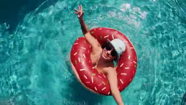 Vue de dessus d'une dame tournant dans un anneau flottant dans la piscine — Video