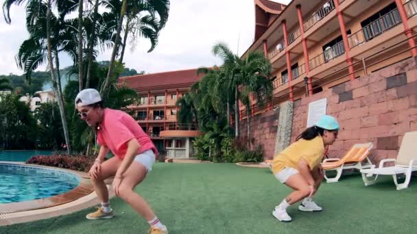 Hotel tropical com duas senhoras fazendo uma dança contemporânea perto dele — Vídeo de Stock