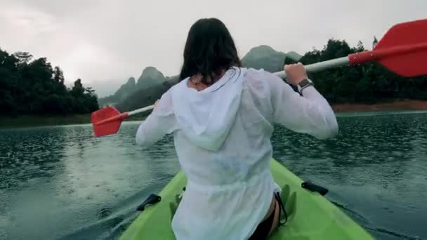 A lady is canoeing towards a water house — Stock Video