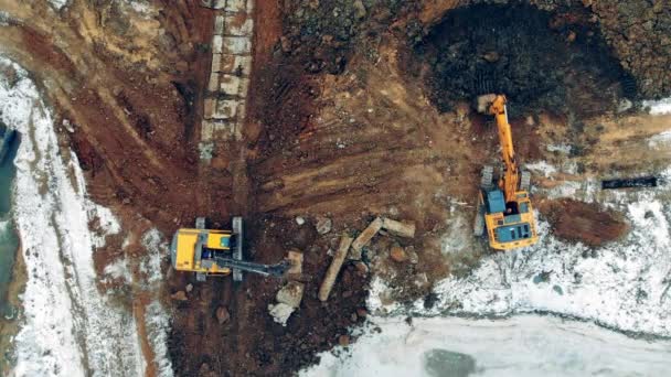 Zwei Traktoren arbeiten in einem Steinbruch und heben Erde aus. Schwere Maschinen auf einer Baustelle. — Stockvideo