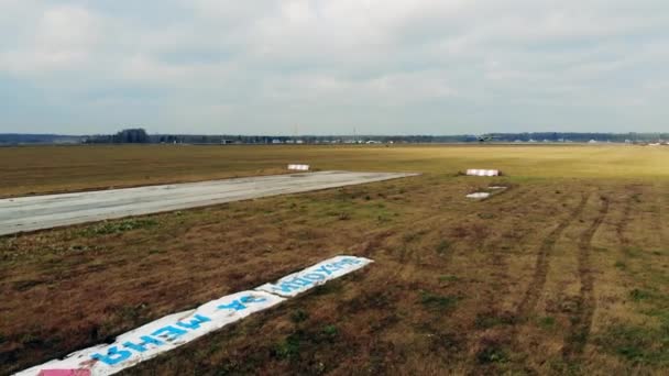 Gammal landningsbana på fälten med en liten jetlandning på — Stockvideo