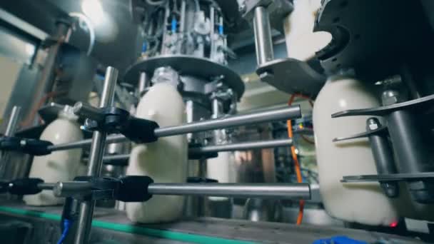 Botellas de plástico con leche moviéndose en una línea de fábrica. Equipos automatizados para la producción y el embalaje de alimentos y bebidas . — Vídeos de Stock