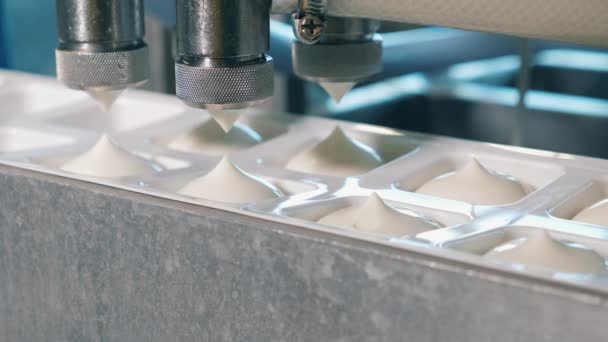 Yogurt poured into containers on a conveyor. Automated production line at a food factory. — 비디오