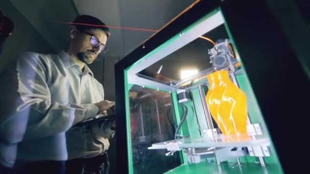 Persoon bestuurt drukmachines met vazen. Professionele industrieel ontwerper creëert 3D-gedrukt product in een ontwerpbureau. — Stockvideo