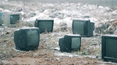 Çöp sahasındaki kapalı televizyonlara kar yağıyor.