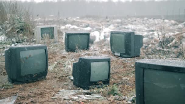 Schneefall auf der Müllkippe mit weggeworfenen Fernsehern — Stockvideo