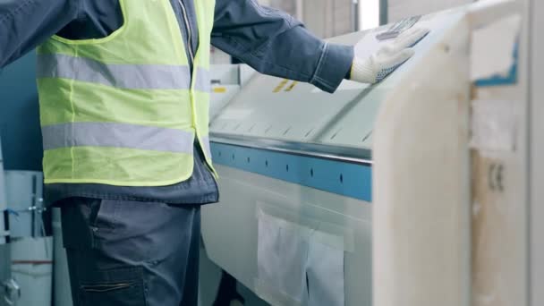 Experto masculino está insertando una hoja de metal en la máquina de procesamiento — Vídeos de Stock