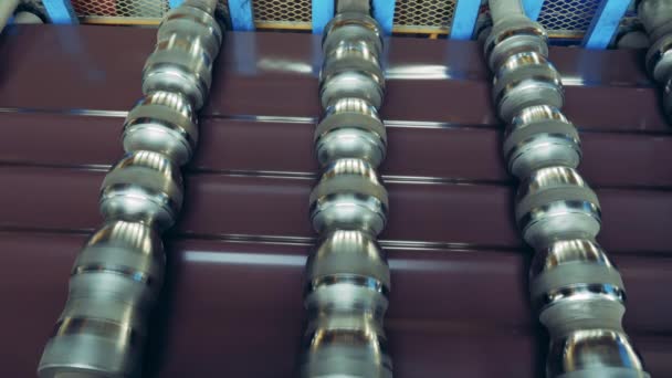 Carretes de un transportador de fábrica con baldosas de metal debajo de ella — Vídeos de Stock