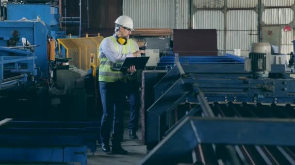 Gli esperti di fabbrica stanno camminando lungo il trasportatore per la lavorazione dei metalli — Video Stock