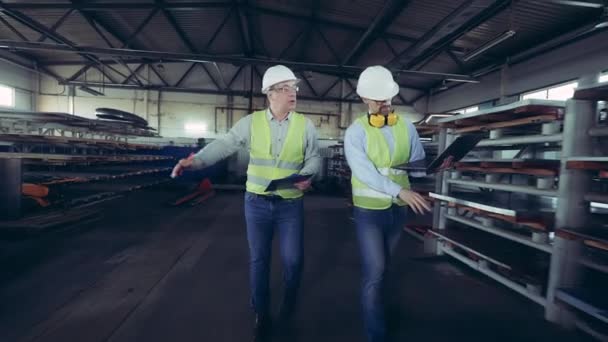 Los inspectores masculinos están caminando a lo largo del almacén de la fábrica de metal — Vídeo de stock