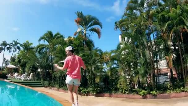 Turista feminina caminha perto de uma piscina, dançando . — Vídeo de Stock