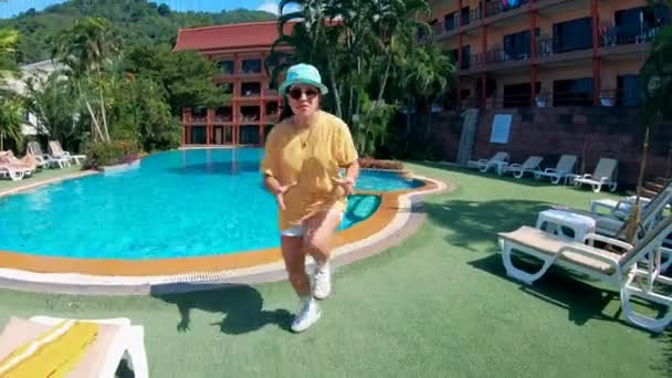 Dívka ve žluté košili tance u bazénu. — Stock video