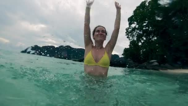 Girl in bikini swims in ocean. — ストック動画