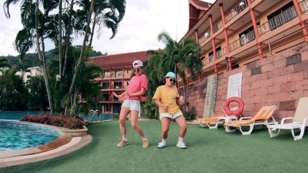Moderne Mädchen tanzen am Pool eines Resorts. — Stockvideo