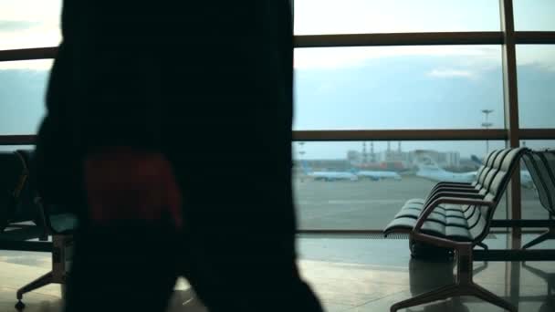 Зал вылета и женщина, управляющая ноутбуком рядом с окнами — стоковое видео