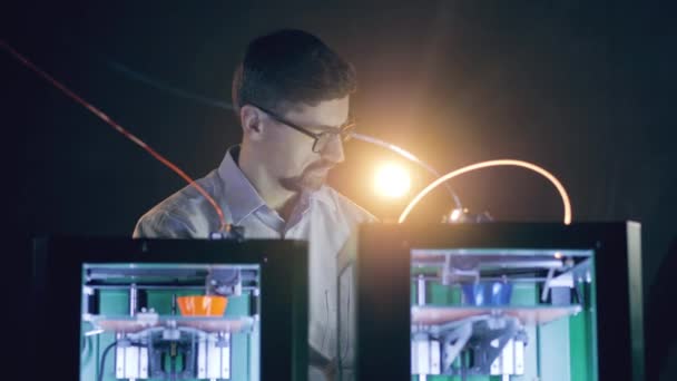 Impresoras 3D en el trabajo está siendo observado por un ingeniero masculino — Vídeo de stock