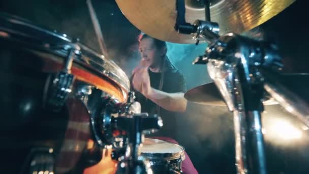 O conjunto de tambores está sendo tocado por um músico masculino. Baterista masculino tocando bateria em fumaça . — Vídeo de Stock