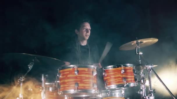 Drum kit in clouds of smoke is being played by a musician — Stock Video