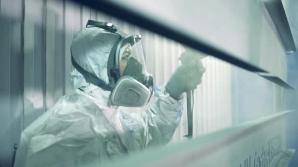 Vrouwelijke werkneemster gebruikt een luchtborstel om metaalplaten te schilderen in een fabriek — Stockvideo