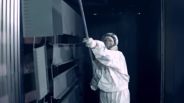 Female worker in safety wear is transporting hung up metal plates — 비디오