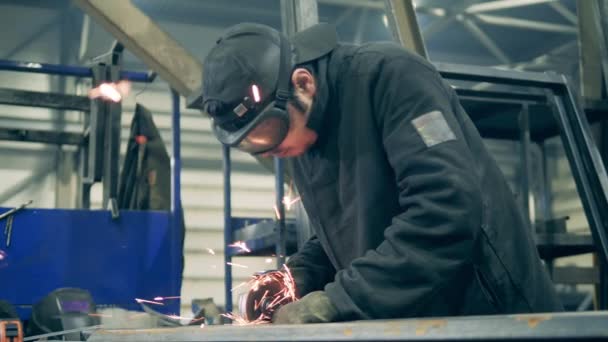 Man svetsare skär metall med en motorsåg — Stockvideo