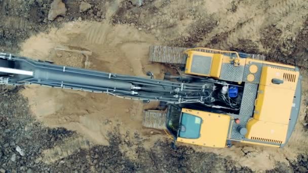Kum kazan bir kazıcının üst görüntüsü. Kazıcı inşaat alanında toprak kazıyor.. — Stok video