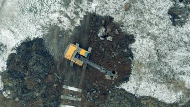 Pelle creusant du sol sur un chantier de construction. Vue de dessus d'une excavatrice creusant un terrain — Video