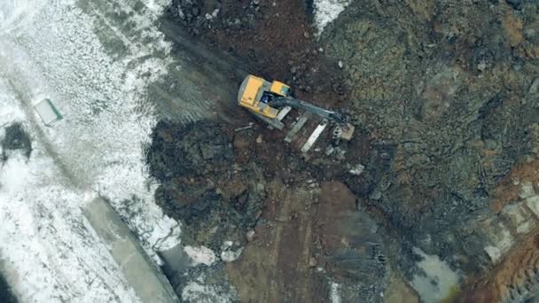 Вид сверху экскаватора, копающего замороженную почву — стоковое видео