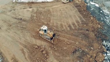 Buldozer taş ocağındaki toprak tabakalarını düzleştiriyor.