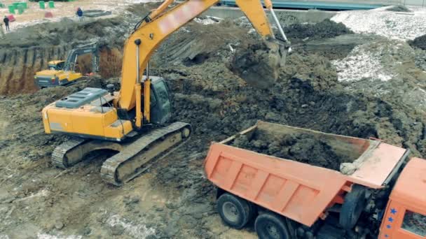 Vrachtwagen wordt gevuld met grond verplaatst door de bulldozer — Stockvideo
