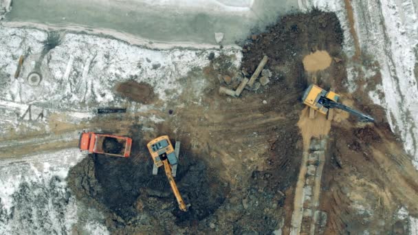 Blick von oben auf ein Steinbruchgelände mit darauf arbeitenden Industriemaschinen — Stockvideo