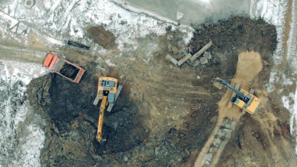 Bulldozers gräver jord vid schaktningsplatsen i en vy uppifrån — Stockvideo