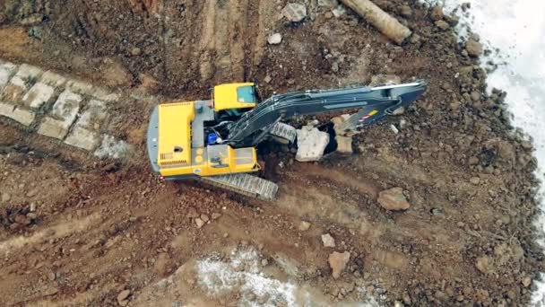 Carregador de escavação está transportando pedras em uma visão superior. Escavadeira cavando solo em um canteiro de obras . — Vídeo de Stock