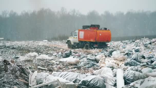 Una máquina sale de un depósito de chatarra con basura . — Vídeos de Stock