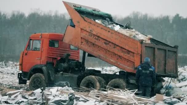 En lastbil lastar av skräp på en soptipp. — Stockvideo