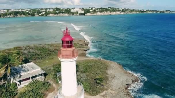 Beyaz deniz feneri olan bir sahil şeridi. Güzel deniz fenerinin drone çekimi. — Stok video