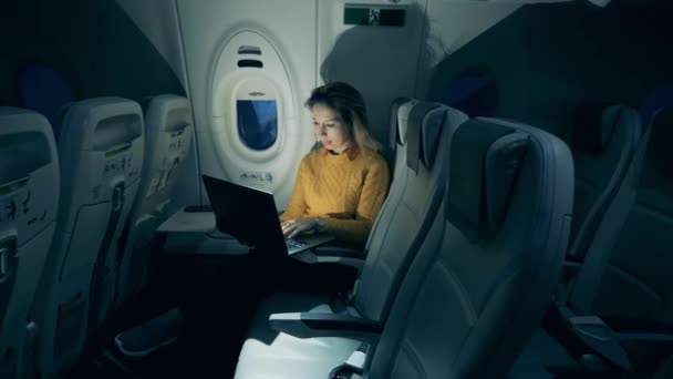 Magnifique dame utilise un ordinateur portable sur l'avion la nuit — Video