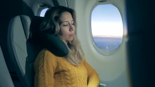 Жінка розслабляється, намагаючись спати на літаку — стокове відео
