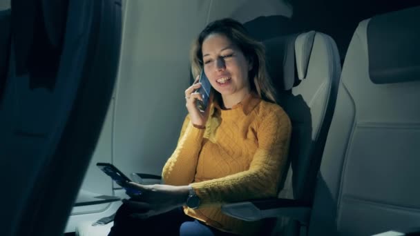 飛行機のキャビンに女性が電話で話してる — ストック動画